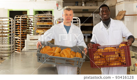 Bakers arranging bakery products Bakers arranging bakery products 93416128