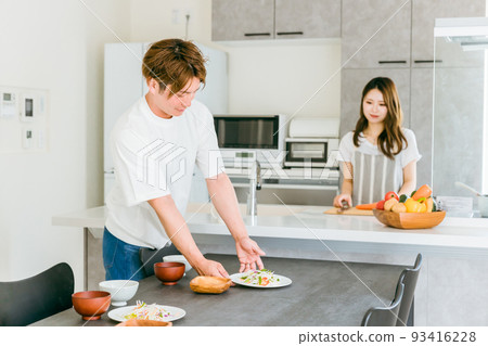 A man and a woman (couple) who help prepare meals 93416228