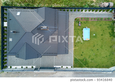Aerial view of private house with green backyard and small swimming pool on grass lawn. 93416840