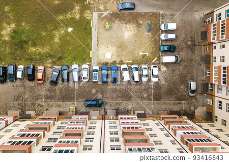 Aerial view of parked cars on parking lot between high apartment buildings. 93416843