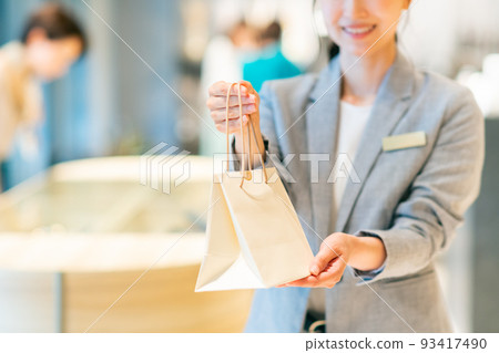 一位年輕的女店員交出產品 攝影合作：g GIFT AND LIFESTYLE 93417490