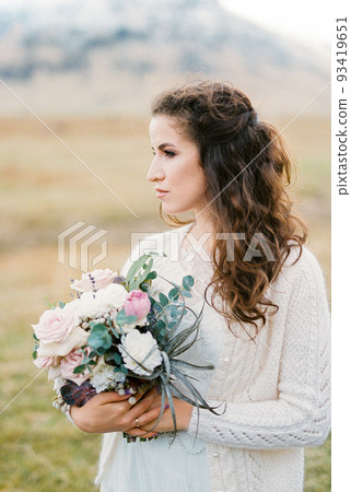 Bride with a bouquet of flowers in a valley. Portrait Bride with a bouquet of flowers in a valley. Portrait 93419651