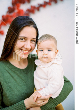 Smiling mother with a baby in her arms. Portrait Smiling mother with a baby in her arms. Portrait 93419814