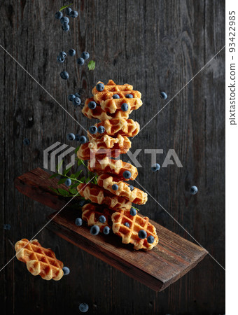 Waffles with fresh blueberries in motion. Waffles with fresh blueberries in motion. 93422985