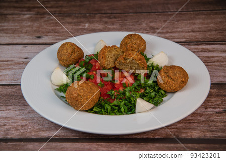 Vegetarian dish, falafel balls from spiced chickpeas with chopped parsley, fresh onions and tomato 93423201