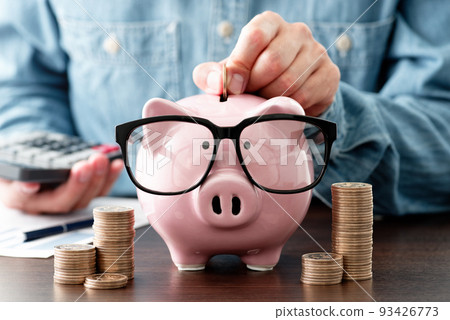 savings image. Put a coin in the piggy bank. household management. Calculation of income and expenses. savings image. Put a coin in the piggy bank. household management. Calculation of income and expenses. 93426773