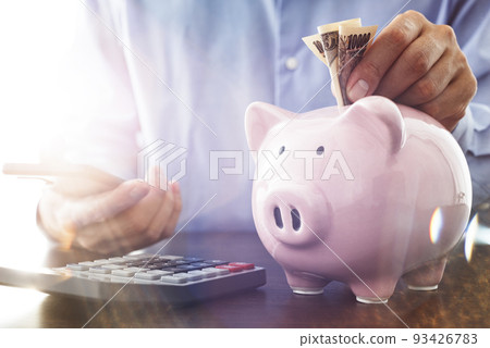 儲蓄形象。在存錢罐裡放一枚硬幣。收入和支出的計算。 儲蓄形象。在存錢罐裡放一枚硬幣。收入和支出的計算。 93426783