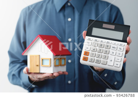 A man with a model of a house and a calculator. An image of a man presenting a price. 93426788