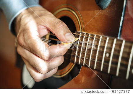 Playing the acoustic guitar. The musician plays country rock and blues on a classical acoustic guitar. Music, creativity, sound concept. 93427577