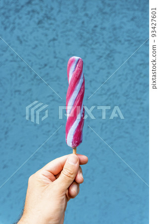 Ice cream cone in hand on minimal color background isolated. Summer, food, sweets, ice cream concept. 93427601