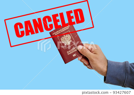 Russian foreign passport in the hands of a man. Prohibition of Schengen visas for Russian tourists to travel to the European Union concept. 93427607