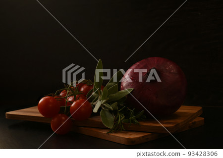 A beautiful branch of ripe cherry tomatoes, a red onion and fresh greens  93428306