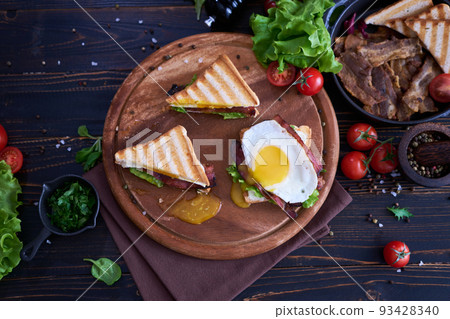 French toasts with fried eggs, cream cheese, salad and bacon 93428340