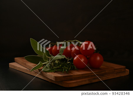 A bunch of greens for cooking meat consisting of greens on a wooden cutting board. 93428346