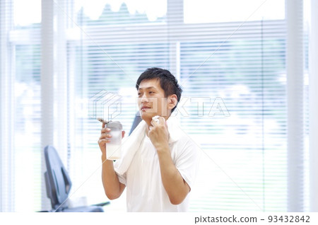 A man drinking protein for a break during exercise 93432842