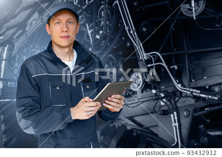Serviceman with digital tablet on a background of the tractor Serviceman with digital tablet on a background of the tractor 93432912