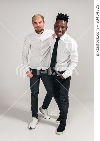 International friendship concept. Studio shot of two stylish young men on white background International friendship concept. Studio shot of two stylish young men on white background 93434825