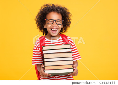 Excited ethnic schoolboy with books laughing against yellow background Excited ethnic schoolboy with books laughing against yellow background 93438411