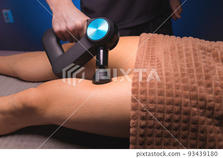 Close-up percussion thigh massage with a special electric device Close-up percussion thigh massage with a special electric device 93439180