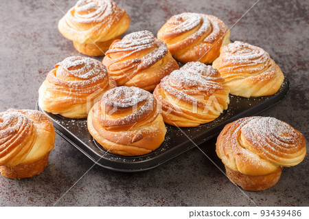 Modern fashionable pastries scones cruffins puffmaffin a mixture of a croissant and maffin closeup in the muffin pan. Horizontal Modern fashionable pastries scones cruffins puffmaffin a mixture of a croissant and maffin closeup in the muffin pan. Horizontal 93439486