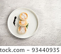 A white plate with cheesecakes on a light background. 93440935