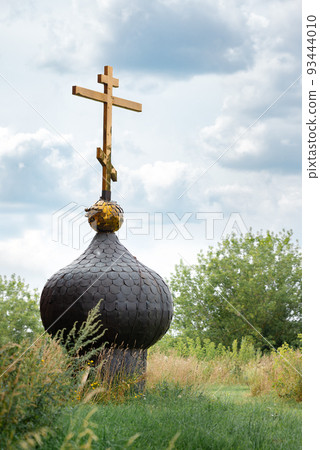Old russsian chirch tip with golden cross separate bring down on ground and grass Old russsian chirch tip with golden cross separate bring down on ground and grass 93444010