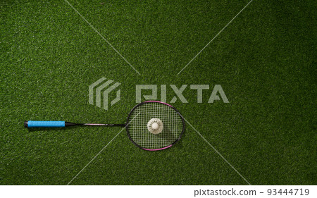 Badminton racket and shuttlecock on green grass background. Badminton racket and shuttlecock on green grass background. 93444719