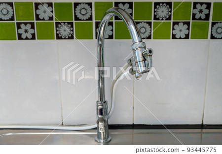 The chrome tap with the water drop after washing. 93445775