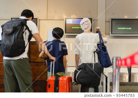 Family standing with luggage check in at airport. Family standing with luggage check in at airport. 93445783