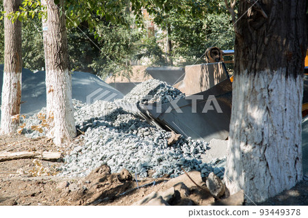 Construction loader bucket filled with rubble at construction site 93449378