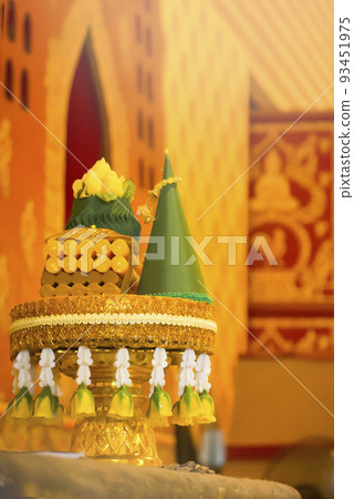 Golden Tray with pedestal is decorated with beautiful Thai flowers for respect buddha and it is placed with respect in chapel, art of Thailand traditional. Golden Tray with pedestal is decorated with beautiful Thai flowers for respect buddha and it is placed with respect in chapel, art of Thailand traditional. 93451975
