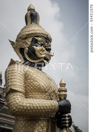 Portrait Thai giant statute standing in front of at gate of temple in Thailand and sky on background with scary image tone. 93451976