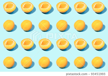 Summer pattern of ripe apricots on a blue background - fruit harvest concept - whole apricots and halves 93451993