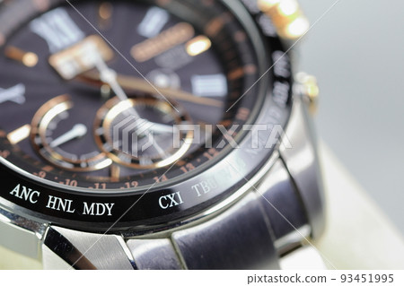 close up shallow focus Time zone cities code on luxury world time watch bezel on ANC  Anchorage, HNL Honolulu, MDY Midway, CXI Kiribati. 93451995