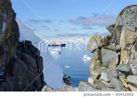 Expedition ship with iceberg in Antarctic sea aerial view  93452002