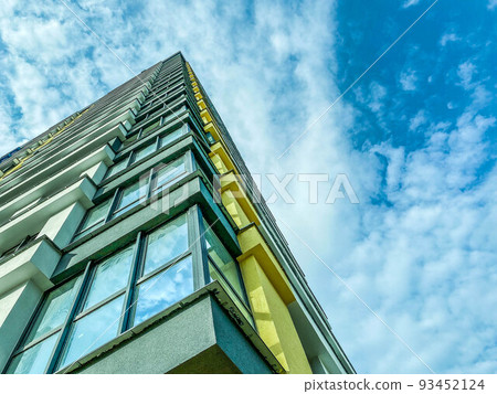 high-rise block building. corner of the house with glass and panoramic windows, block walls. modern high-rise building for people's lives high-rise block building. corner of the house with glass and panoramic windows, block walls. modern high-rise building for people's lives 93452124