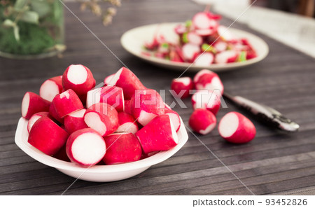 cooked crispy radish in white bowl on wooden table 93452826