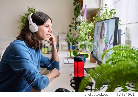 Online meeting of teenagers friends, guy at home talking with smiling girl Online meeting of teenagers friends, guy at home talking with smiling girl 93454601