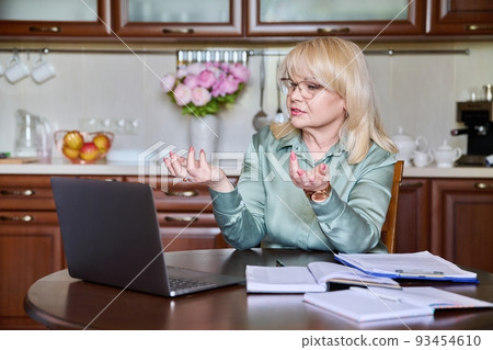 Senior business woman working remotely using laptop for video call Senior business woman working remotely using laptop for video call 93454610