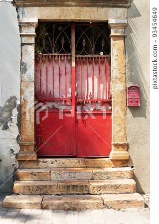 Old metal red doors with stone steps and columns Old metal red doors with stone steps and columns 93454649