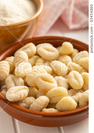 Uncooked potato gnocchi in bowl. Tasty italian food. Uncooked potato gnocchi in bowl. Tasty italian food. 93454860