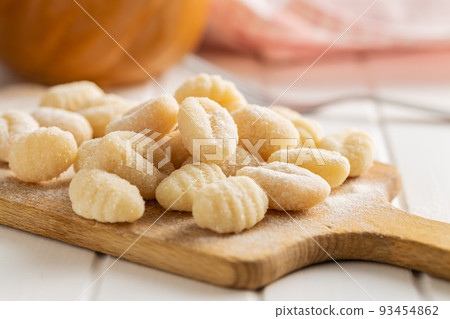 Uncooked potato gnocchi on cutting board. Tasty italian food. Uncooked potato gnocchi on cutting board. Tasty italian food. 93454862