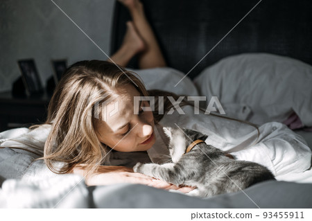 Mindfulness, Being in the present moment, here and now. Young woman play with kitten at home in morning Mindfulness, Being in the present moment, here and now. Young woman play with kitten at home in morning 93455911