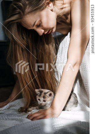 Mindfulness, Being in the present moment, here and now. Young woman play with kitten at home in morning Mindfulness, Being in the present moment, here and now. Young woman play with kitten at home in morning 93455913