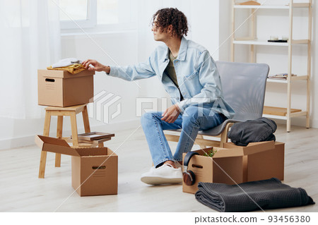 handsome guy cardboard boxes in the room unpacking interior 93456380