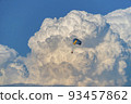 Parasailing over the sea, against the background of huge cumulus clouds. 93457862