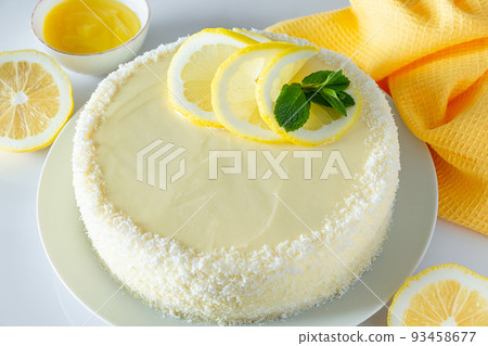 Lemon cake with coconut flakes and white cream, vanilla holiday dessert. Lemon cake with coconut flakes and white cream, vanilla holiday dessert. 93458677