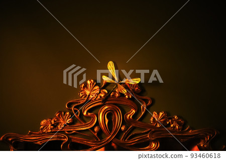Forged fragment of interior mirror. Frame metal ornament. Interior decorative element with dragonfly. Mirror frame with dragonfly. Blurred image 93460618