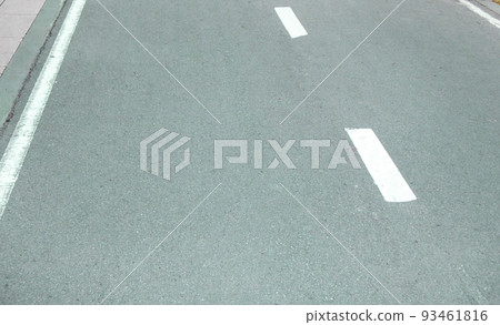 Close-up of an asphalt road with an intermittent marking line. Selective focus Close-up of an asphalt road with an intermittent marking line. Selective focus 93461816
