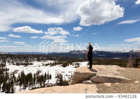 Woman standing at Scenic Viewpoint surrounded by Mountains and Trees Woman standing at Scenic Viewpoint surrounded by Mountains and Trees 93462126